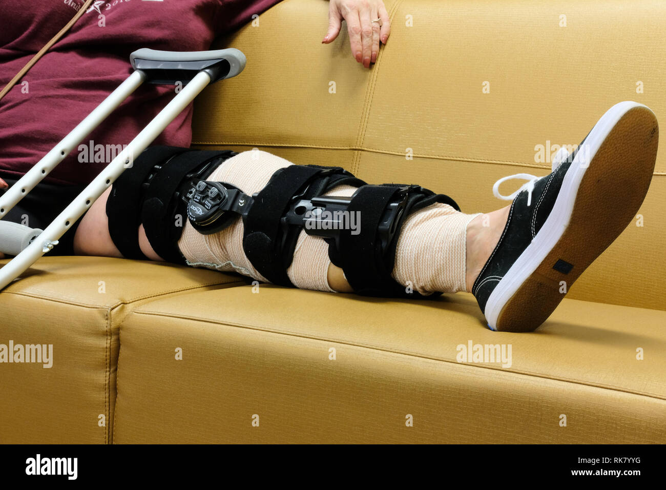 Close up of female wearing full length postop knee support on left leg