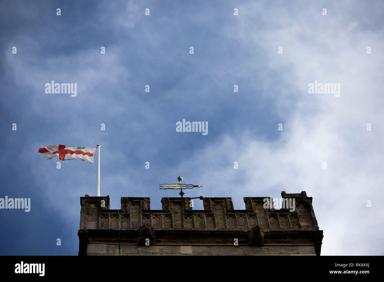 English Saint George flag flying over a medieval church tower against a ...