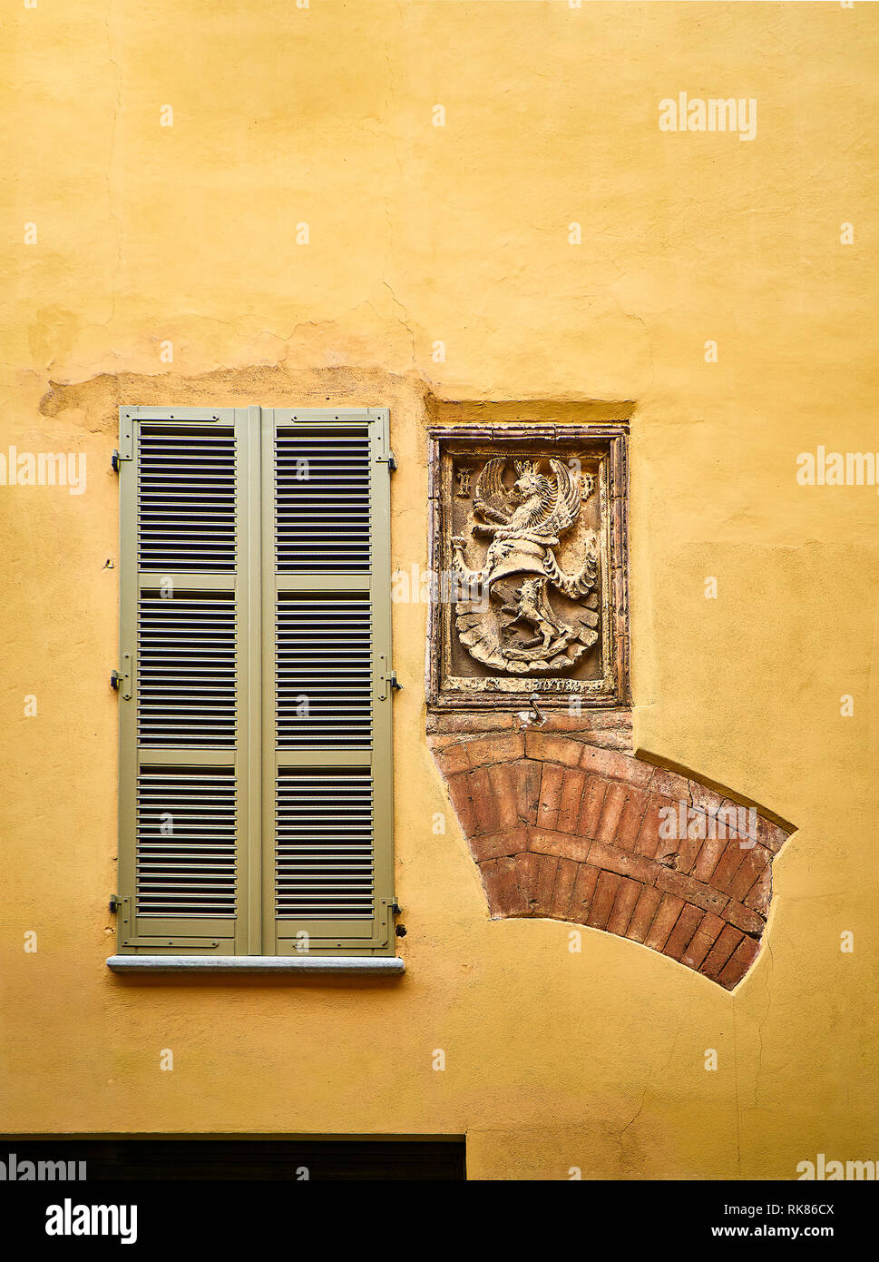 Vestiges of a Medieval Arch and a Blazon on a facade. Asti, Piedmont, Italy. Stock Photo