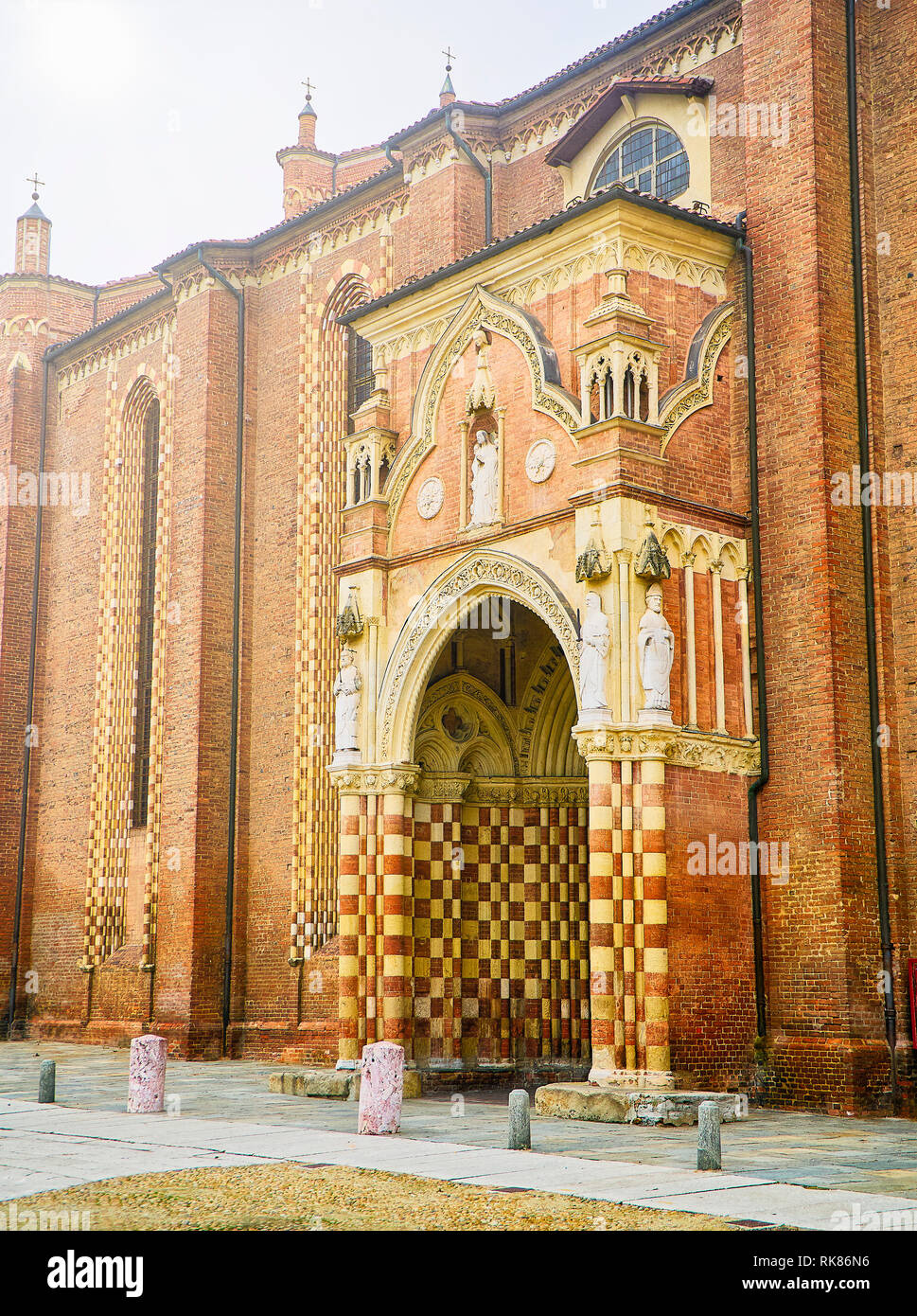 Entry at the lateral facade of The Cattedrale di Santa Maria Assunta e San Gottardo, Asti Cathedral. View from the Piazza Cattedrale square. Asti. Stock Photo