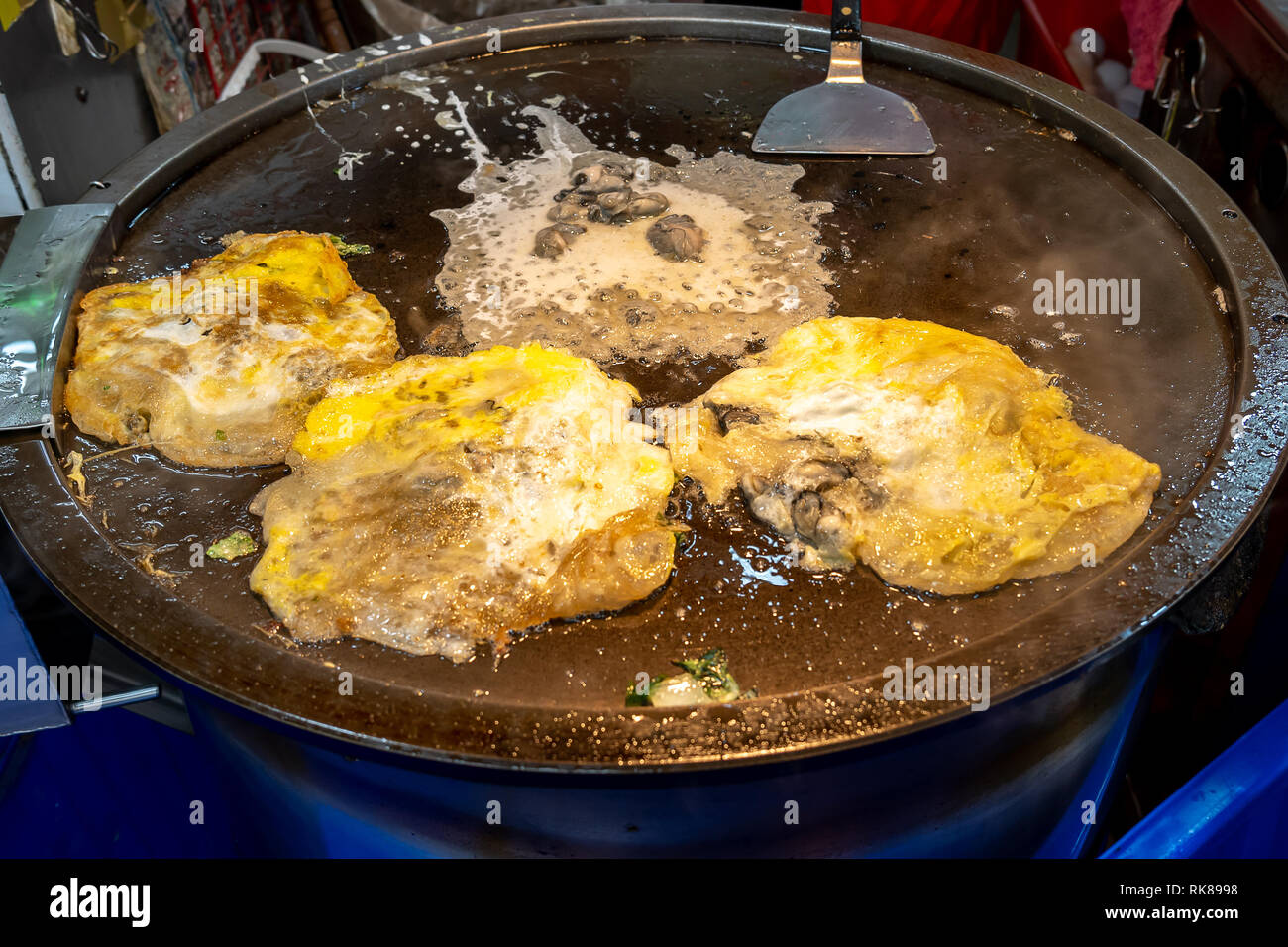 Taiwanese street foods - Oyster omelet  on the hot plate at a street food vendor in the night market in Taipei, Taiwan Stock Photo