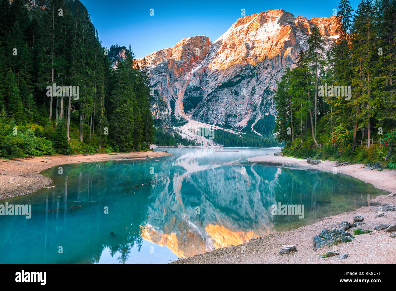 Famous hiking, travel and phtography place. Cute wooden boats on the foggy alpine lake and beautiful snowy mountains at sunrise, lake Braies, Dolomite Stock Photo