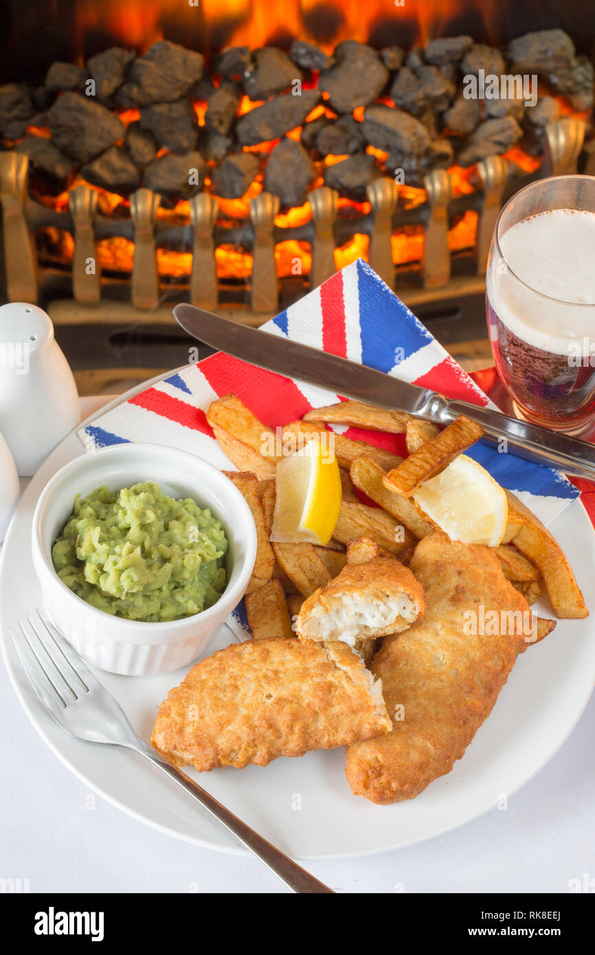 A plate of Traditional English fish and chips with mushy peas. Stock Photo