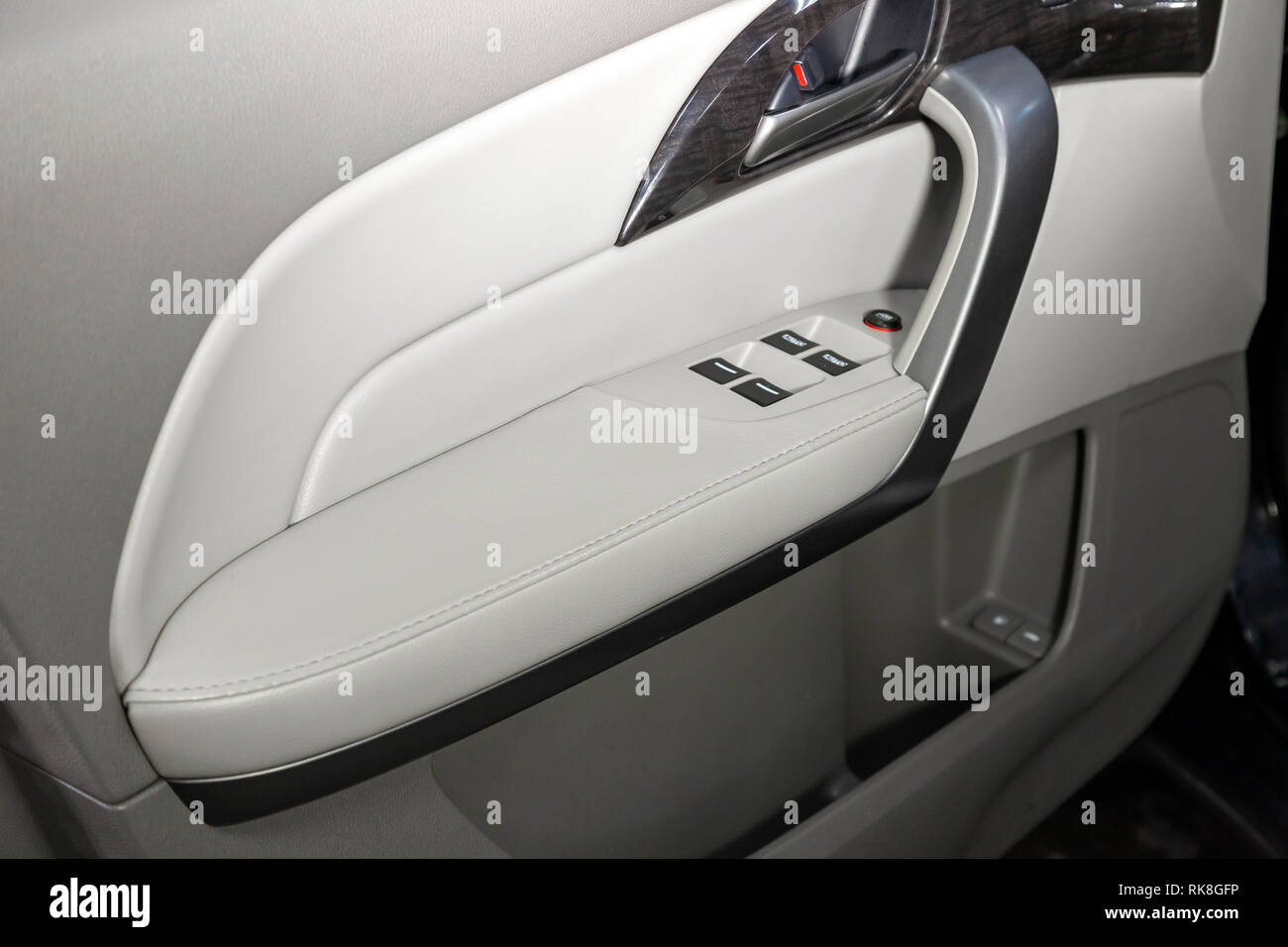 The interior of the car with a view of the drivers door with buttons