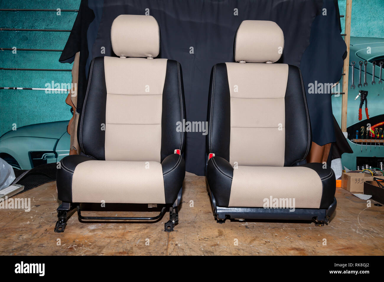 Two front seats with combined leather trim in two colors of black and  beige, located on the workbench in the workshop for repair and tuning of  cars an Stock Photo - Alamy