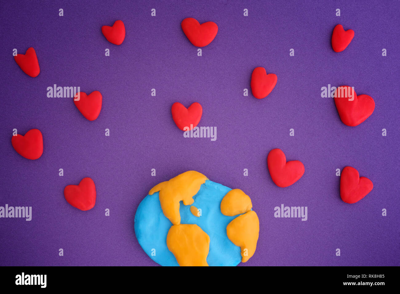 Planet Earth with red hearts. Planet Earth and Hearts are made out of play clay (plasticine). Stock Photo