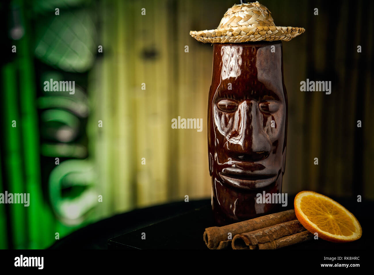 Fruity and long Tiki cocktail served in a long Tiki mug wearing a small straw hat Stock Photo