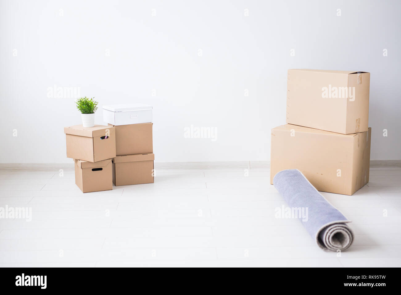 Moving day relocation and new home concept - cardboard boxes in empty apartment with copy space Stock Photo