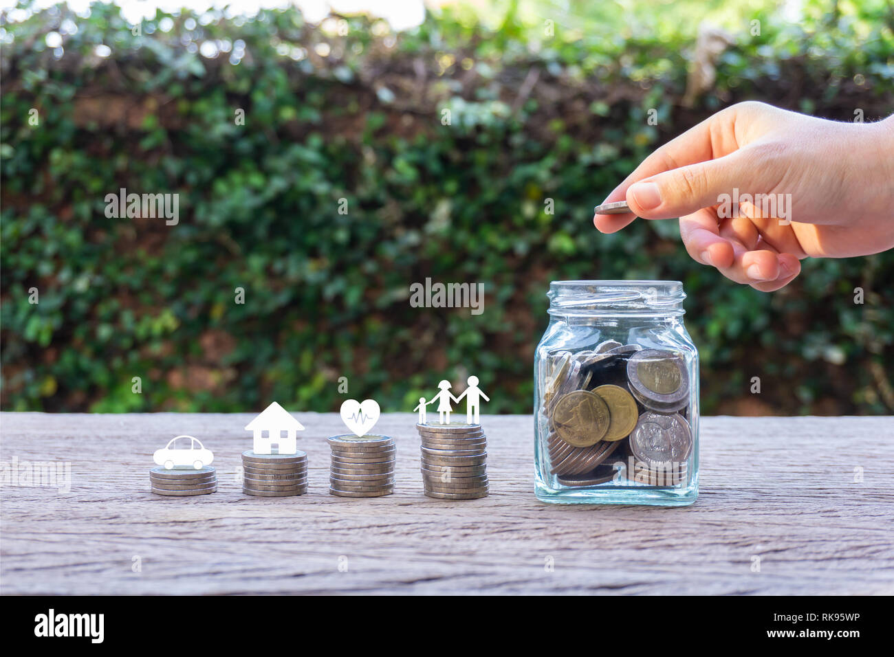 Savings money for family life concepts. Hand holding coin on a full