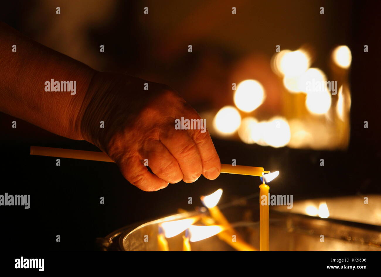 Hand lighting candle in a church Stock Photo - Alamy