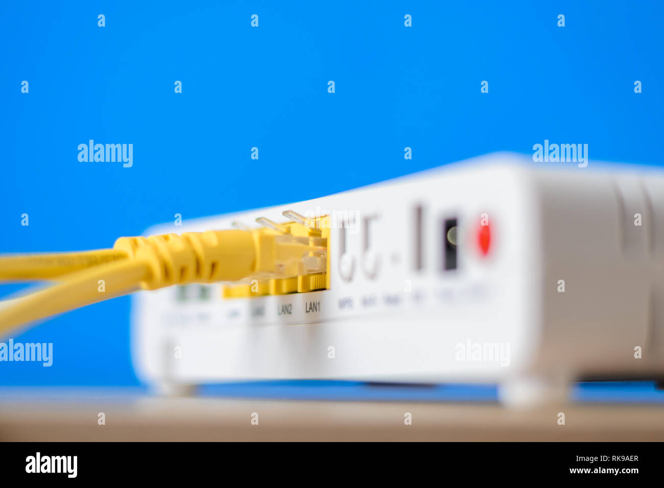 wireless internet router with connecting cables on blue background ...