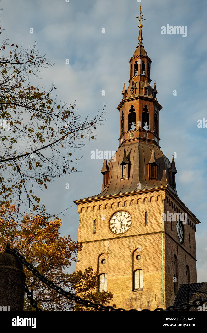 Oslo Cathedral tower in sunshine and yellow leaves during autumn Stock Photo