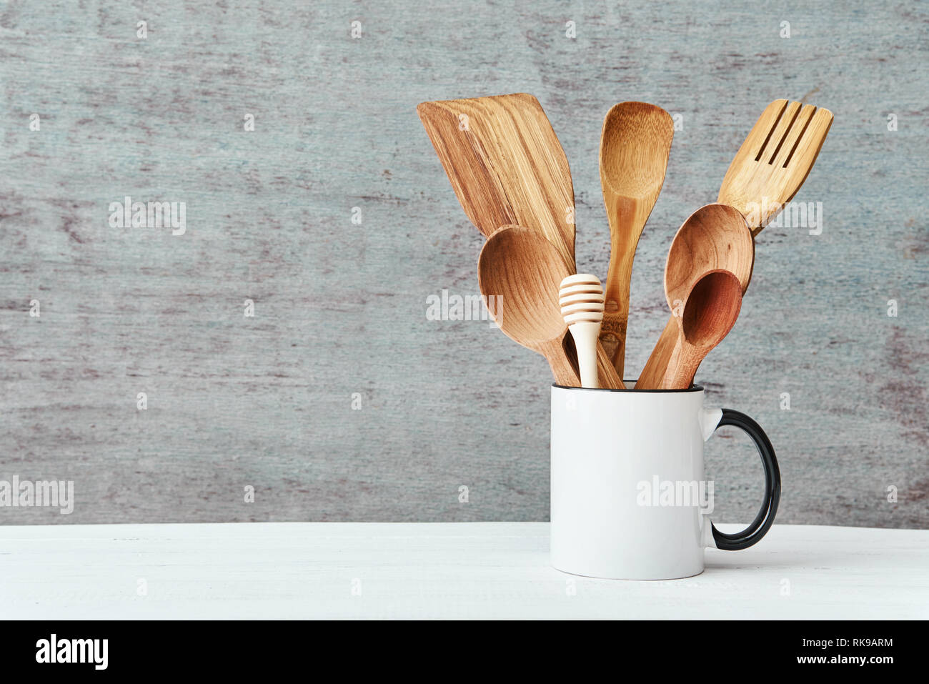 Kitchen utensils in ceramic cup on gray background, copy space Stock Photo