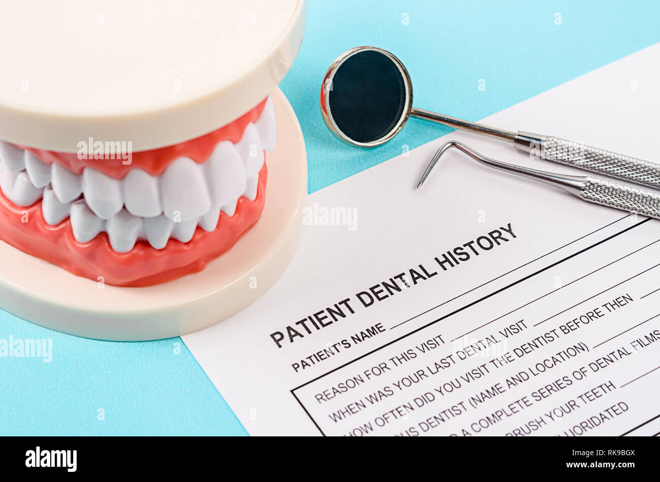 Dental history form with model tooth and dental instruments. Dental health and teeth care