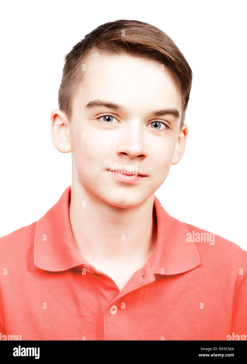 Portrait of cheerful teenager boy wearing living coral trendy color of the year 2019 polo shirt isolated on white background Stock Photo