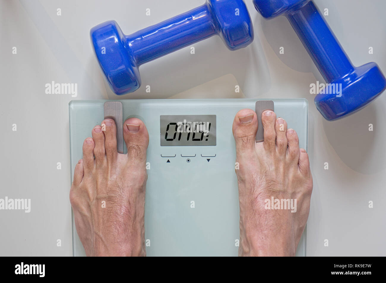 Man standing on scale. View of feet, lifting weights and text omg