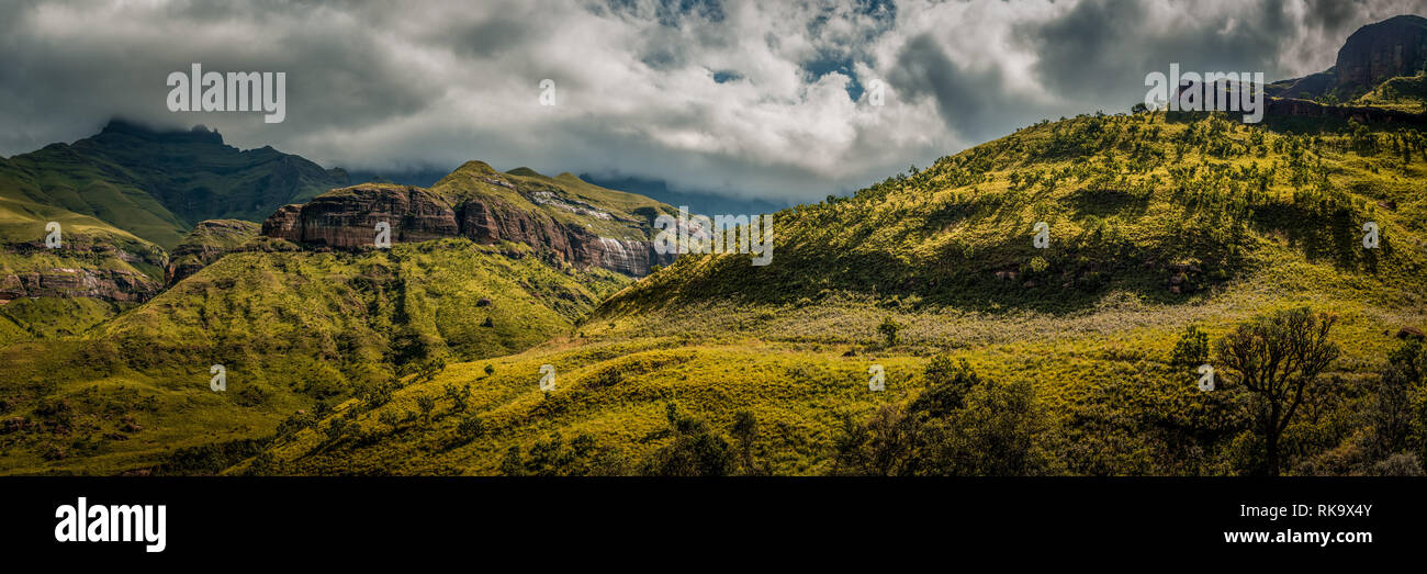Dramatic light on the hills along the Tugela Gorge hiking route at the base of the Amphitheatre mountain; Drakensberg, South Africa Stock Photo