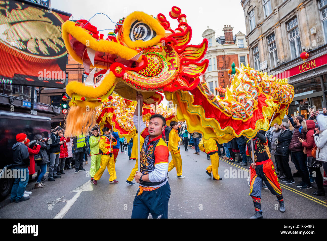 Lion dancers and children in costumes parade around the edges of Chinatown and Soho. Chinese New Year Celebrations in Soho, London. Stock Photo