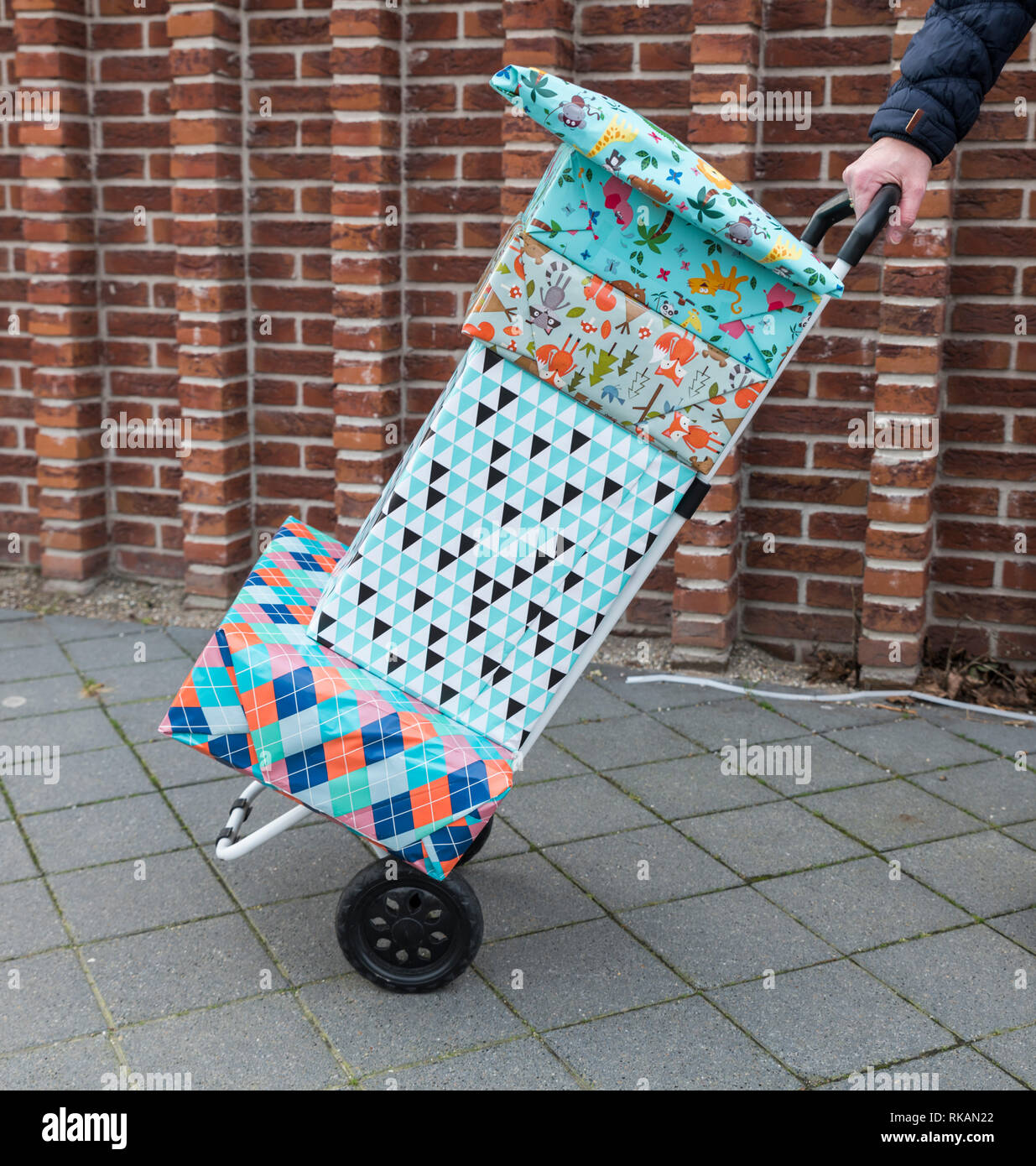 woman with a handtruck full of presents for a birthday party Stock Photo