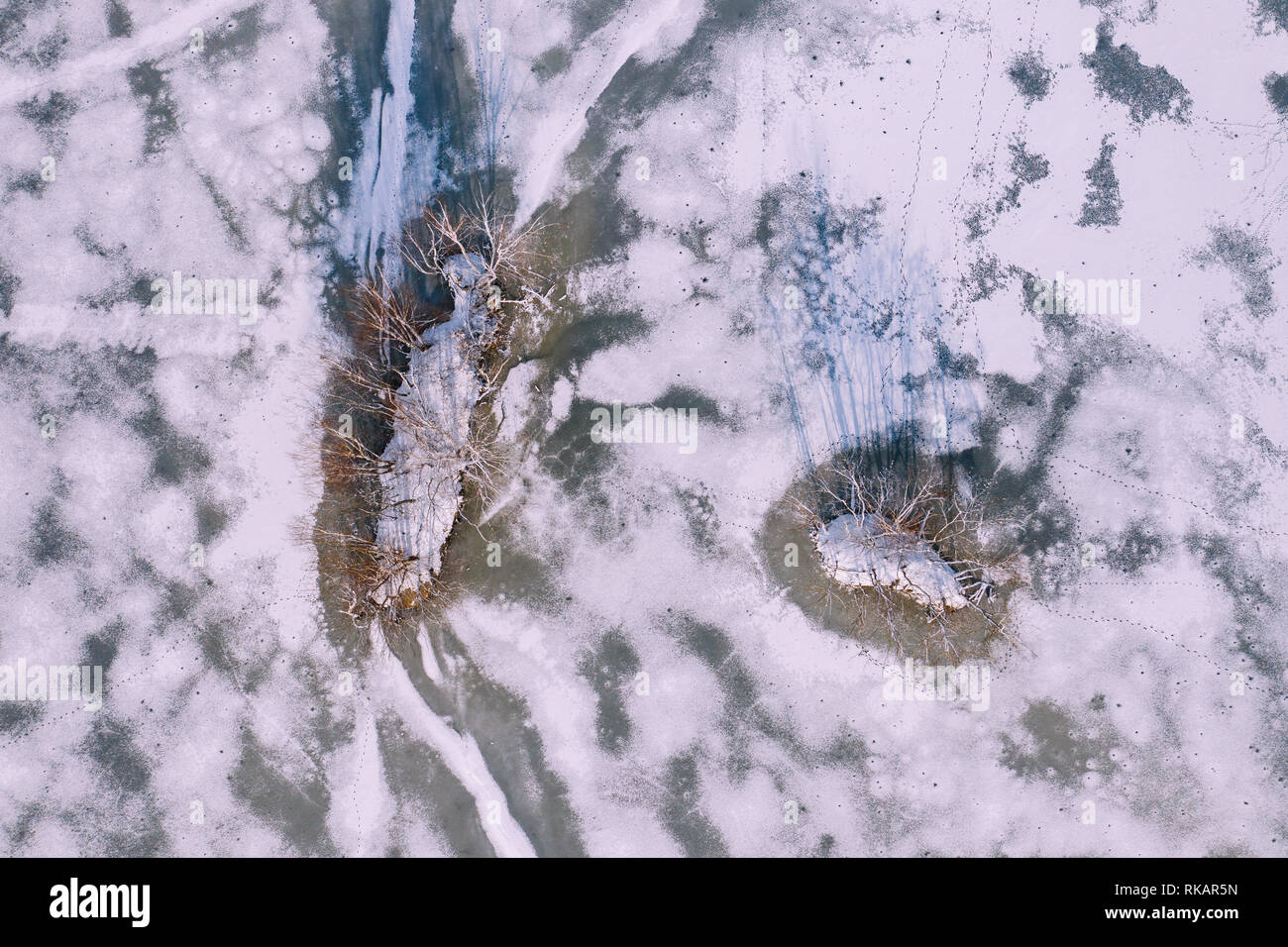 Aerial view of the winter snow covered forest and frozen lake from ...