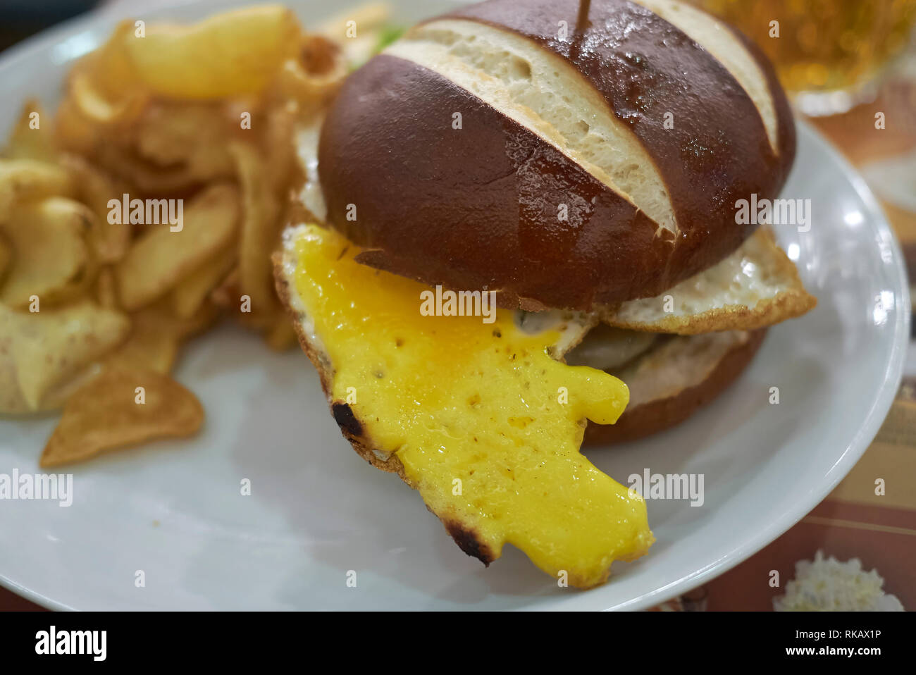 Pretzel sandwich with fried eggs and fries Stock Photo Alamy
