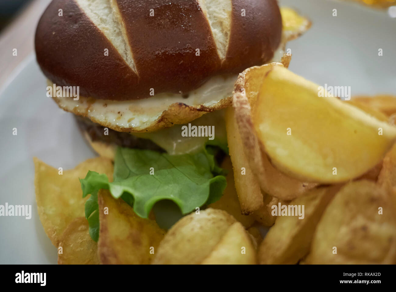 Pretzel sandwich with fried eggs and fries Stock Photo Alamy