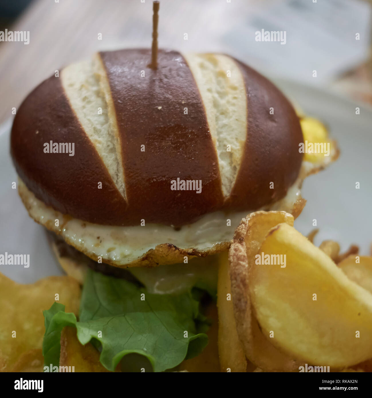 Pretzel sandwich with fried eggs and fries Stock Photo Alamy