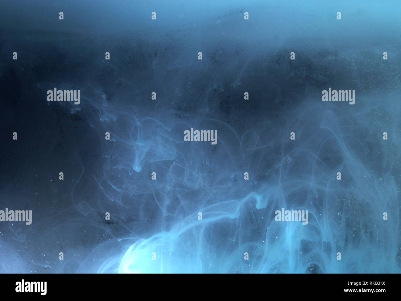 A drop of paint dissolves in water. On black background. Abstract ...