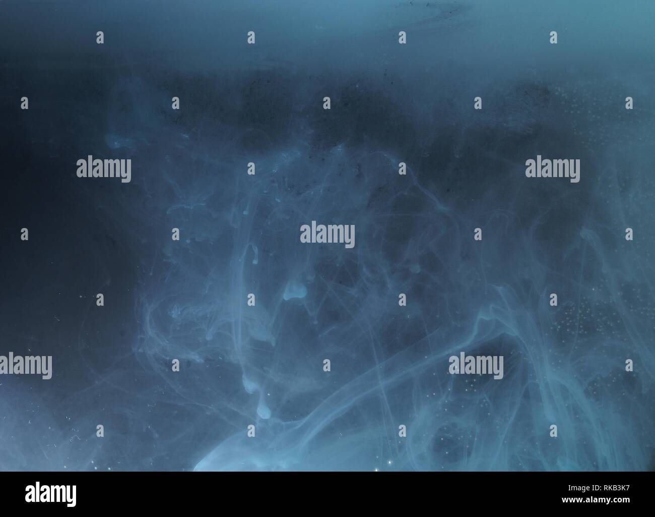 A drop of paint dissolves in water. On black background. Abstract ...