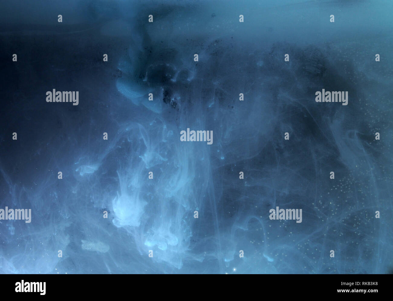 A drop of paint dissolves in water. On black background. Abstract ...