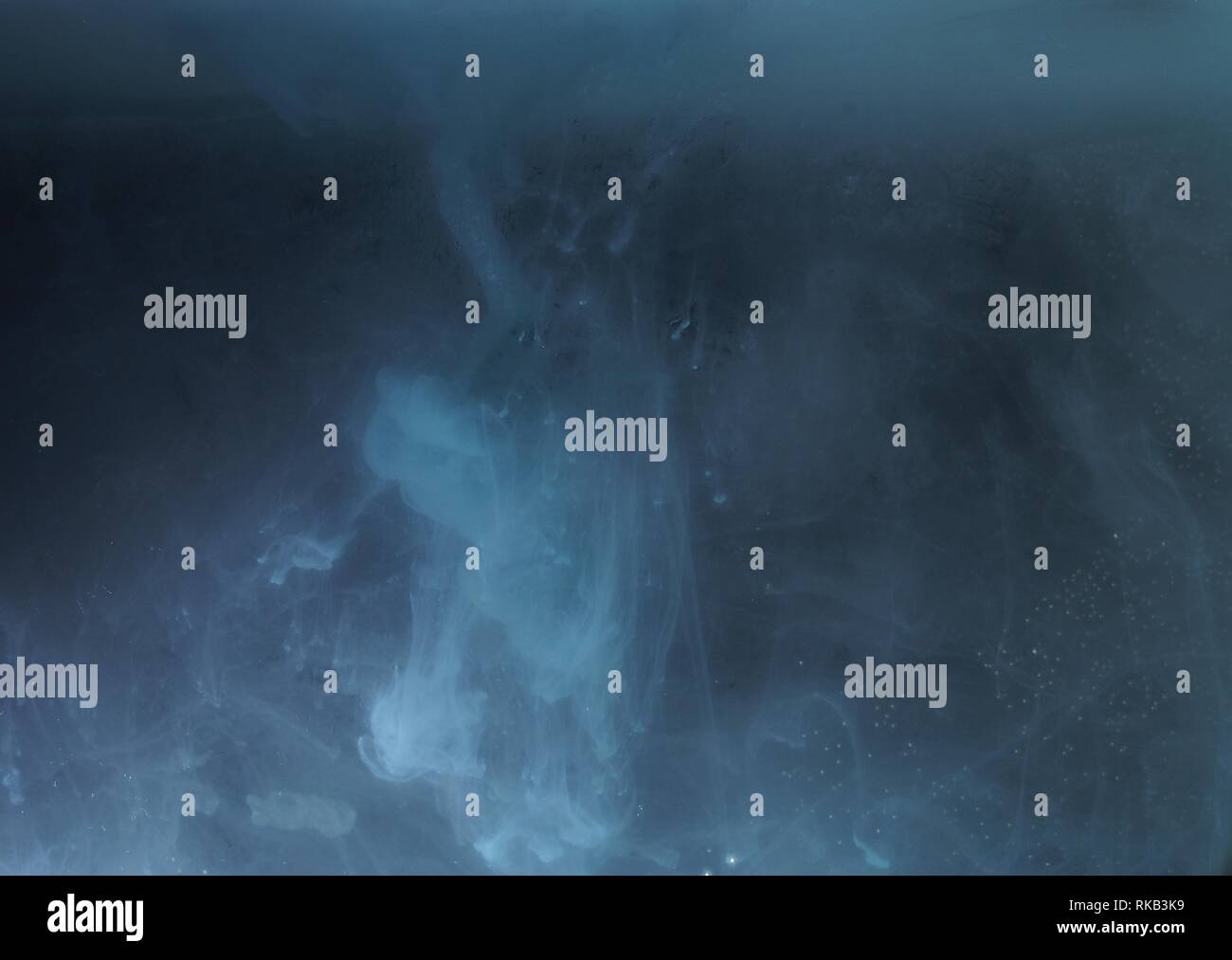 A drop of paint dissolves in water. On black background. Abstract ...