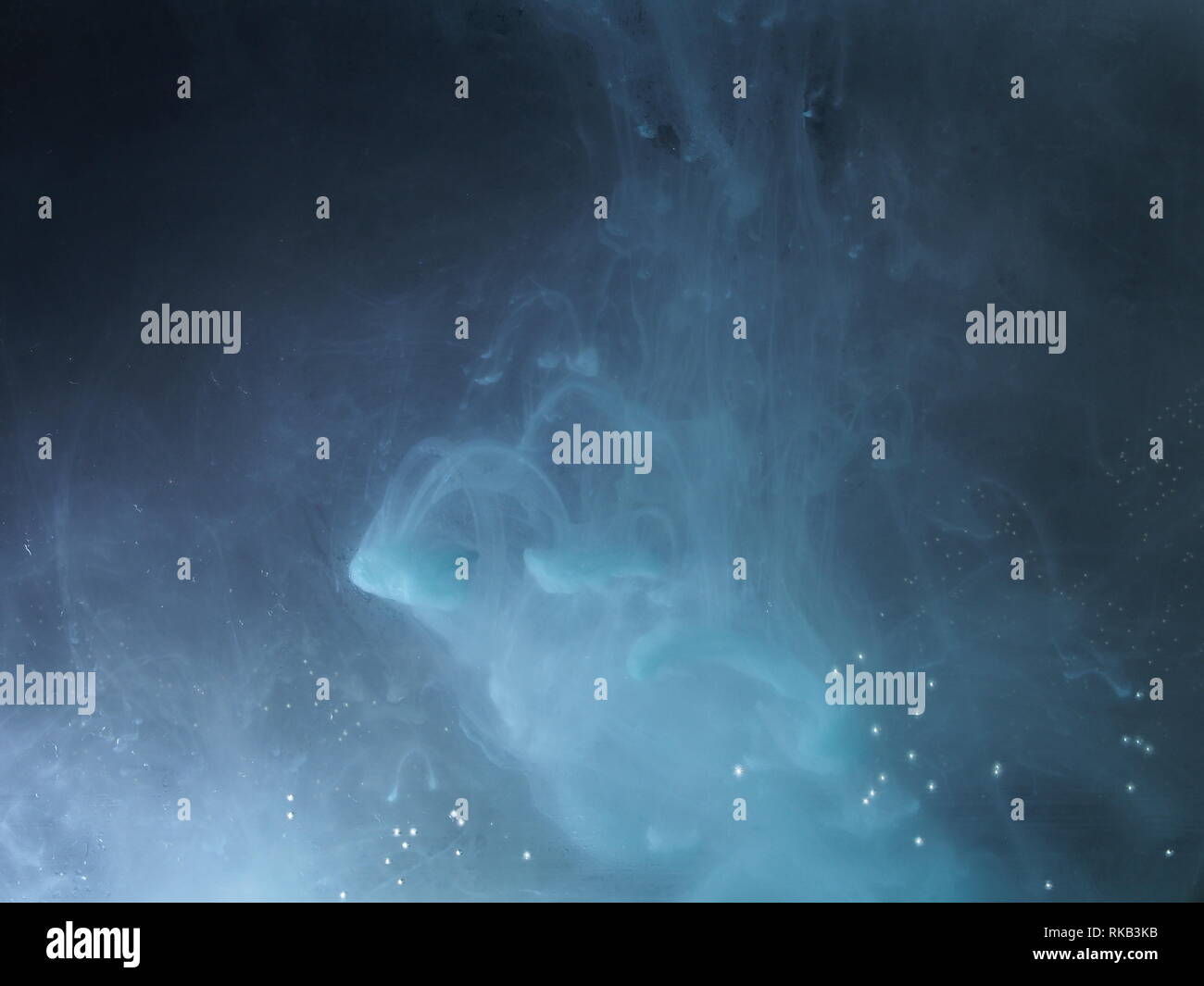 A drop of paint dissolves in water. On black background. Abstract ...