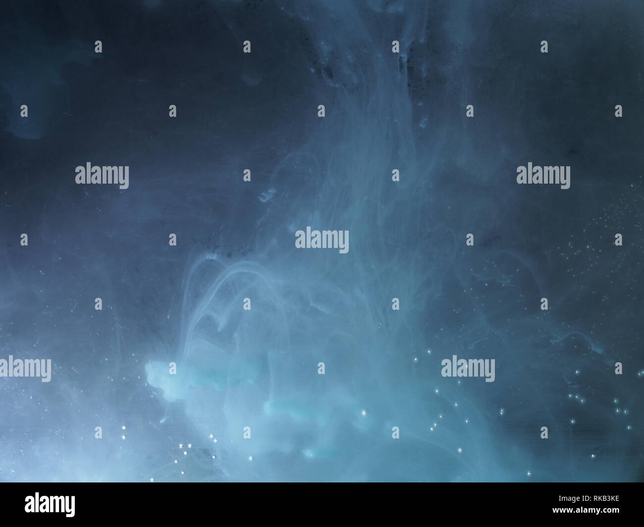 A drop of paint dissolves in water. On black background. Abstract ...