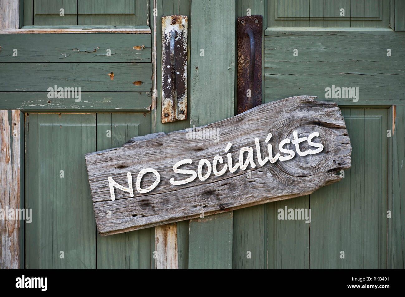 No Socialists allowed inside sign on old green door. Stock Photo