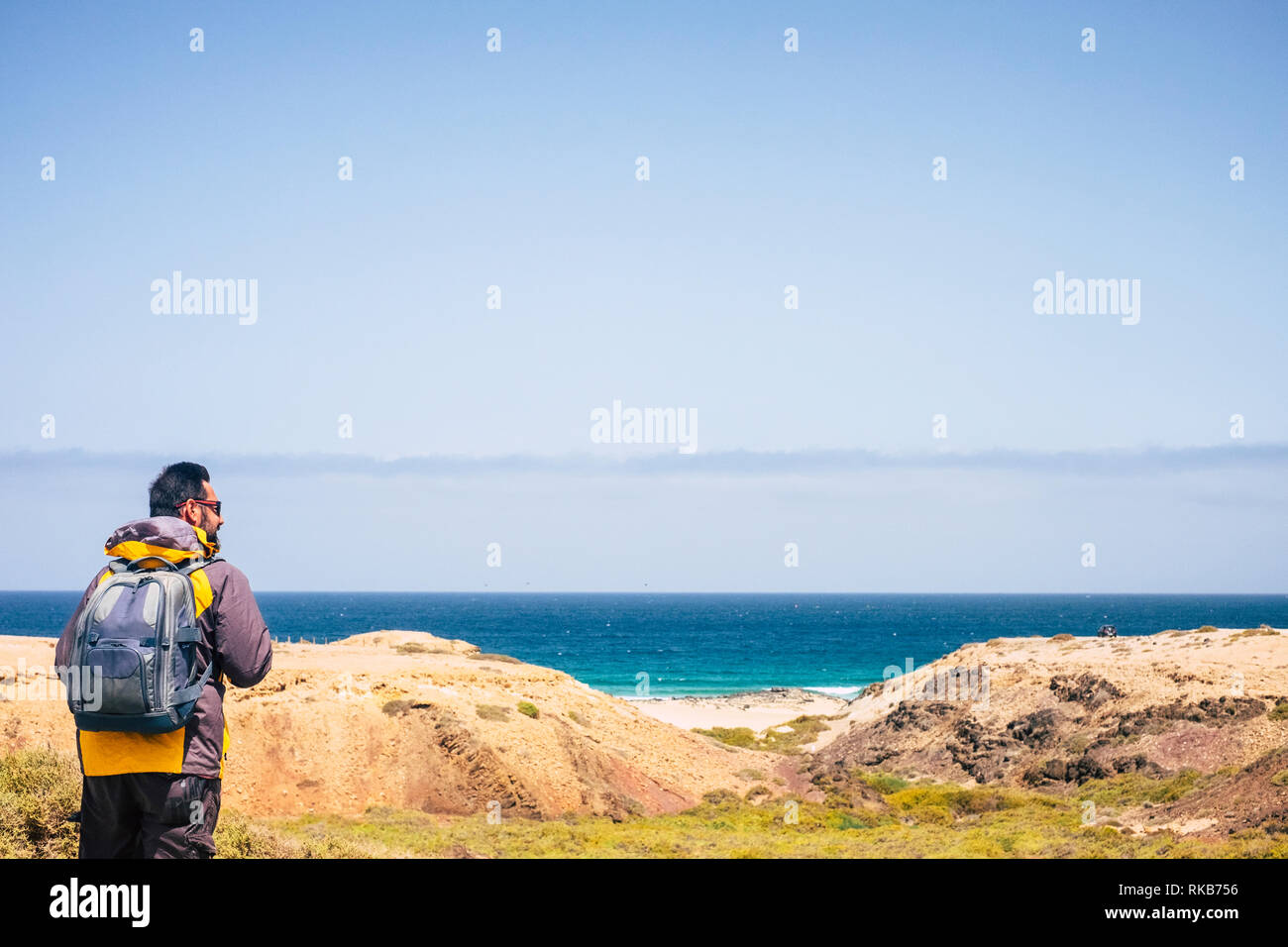Lonely hiker backpacker man do trekking in tropical place with ocean and beach in background - enjoying nature and feel the freedom for people who lov Stock Photo