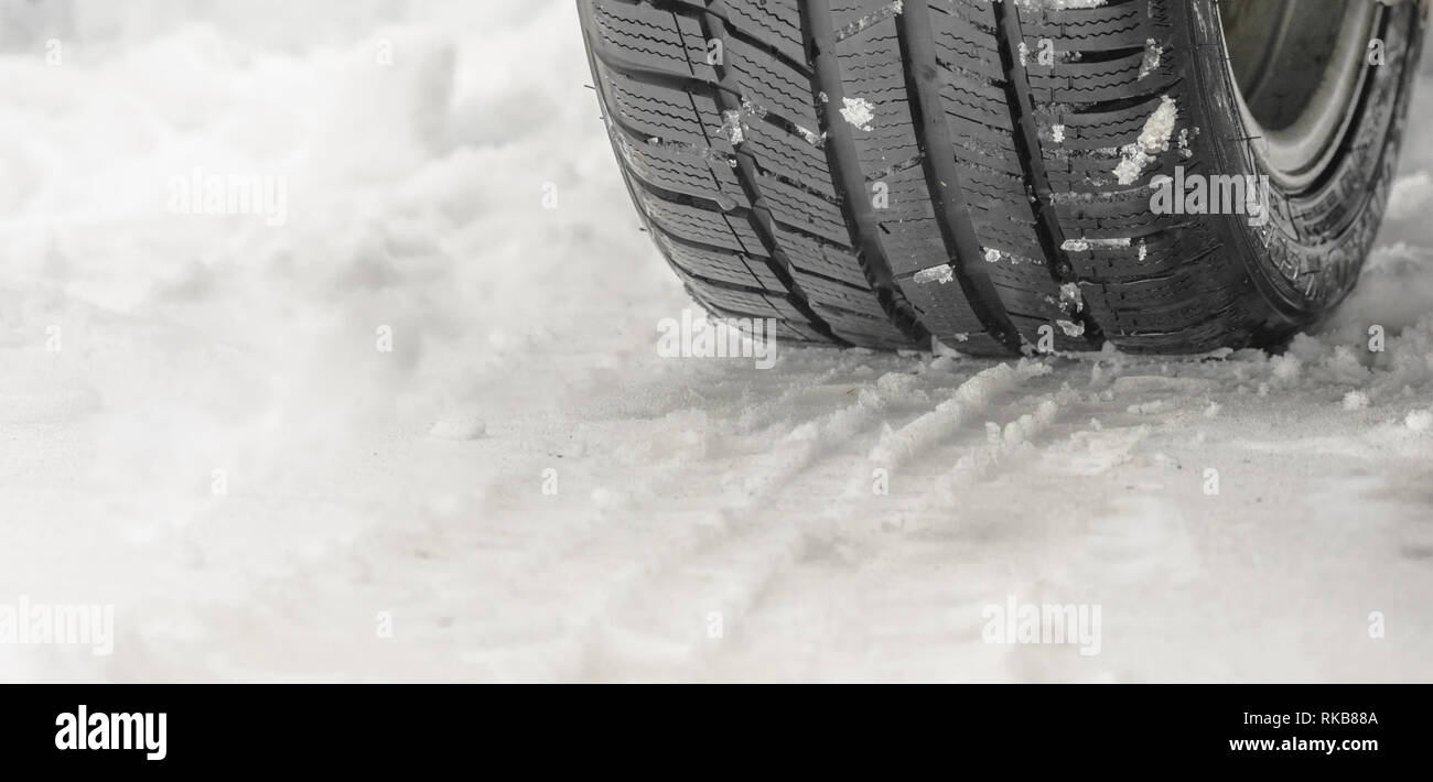 detail of a winter tire of a car on the snow, tread close up Stock Photo