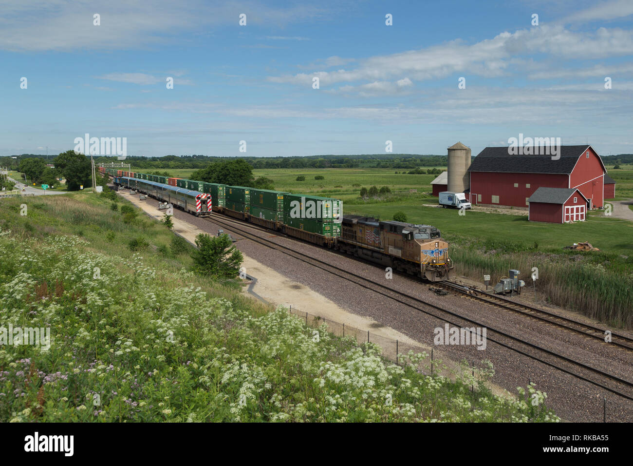 A Union Pacific container train meets a Metra commuter train outside of Elburn, Illinois. Stock Photo