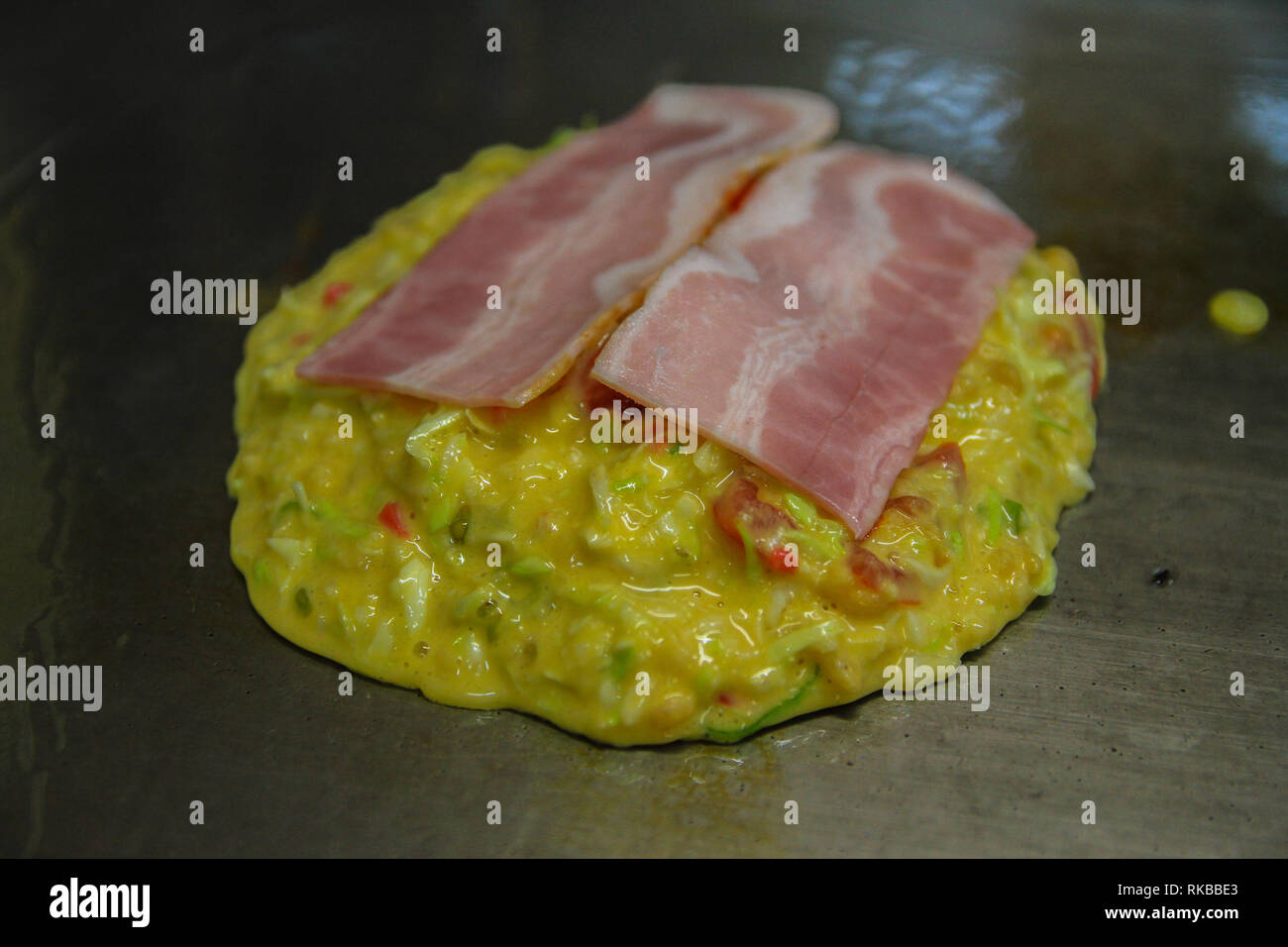 Preparation of Okonomiyaki of bacon and egg at Kyoto, Japan Stock Photo