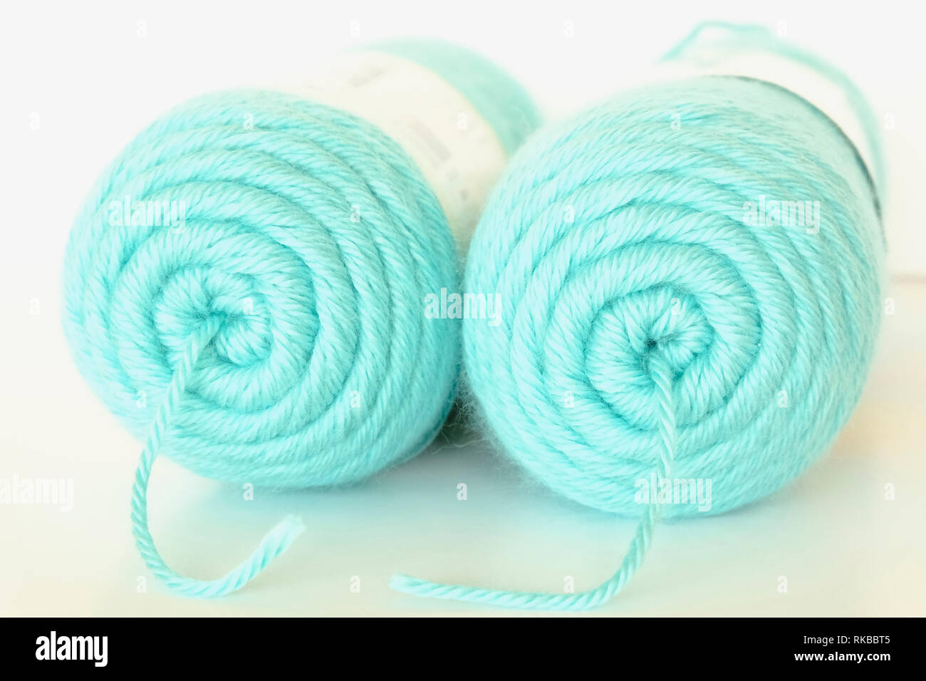 Two large balls of duck egg blue knitting wool against a white background Stock Photo