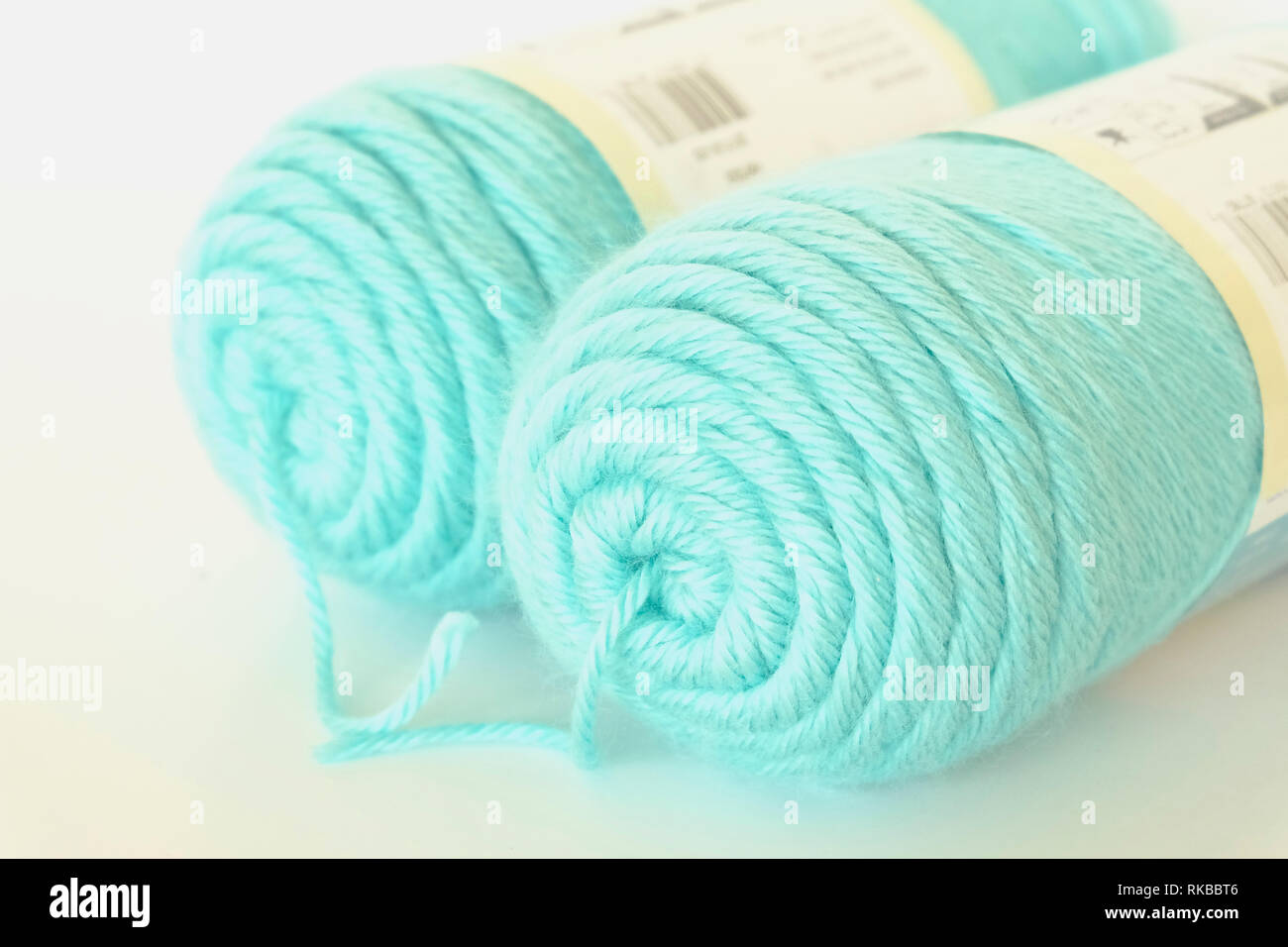 Two large balls of duck egg blue knitting wool against a white background Stock Photo