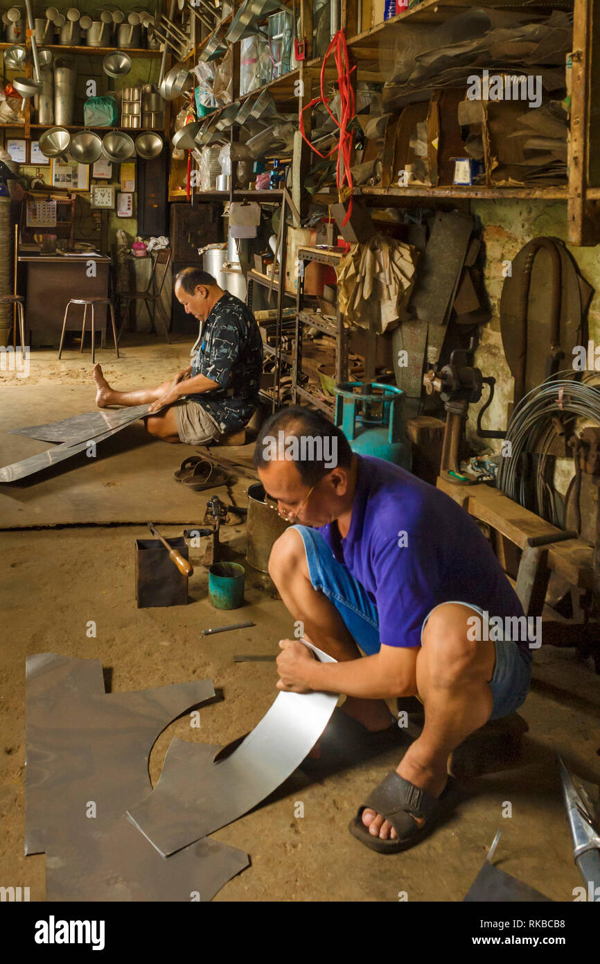 Tin Smith fabricating metal wares, such as pots, pans, in old town of Ipoh, Perak, Malaysia Stock Photo