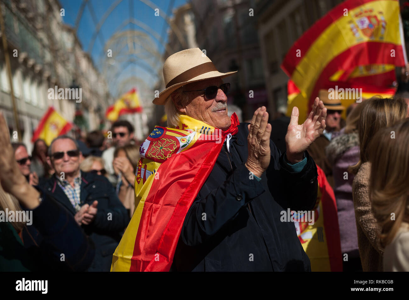 A supporter of the unite between Spain and Catalonia called by right parties, is seen applauding with a Spanish flag as he takes part in a demonstration against the Spanish government of Pedro Sánchez. Stock Photo