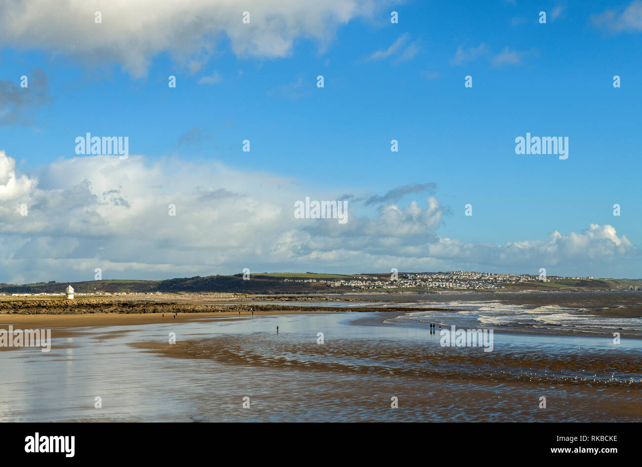 Coney Beach at Porthcawl on the south Wales coast on a cold sunny February day with a few people taking a stroll. Stock Photo