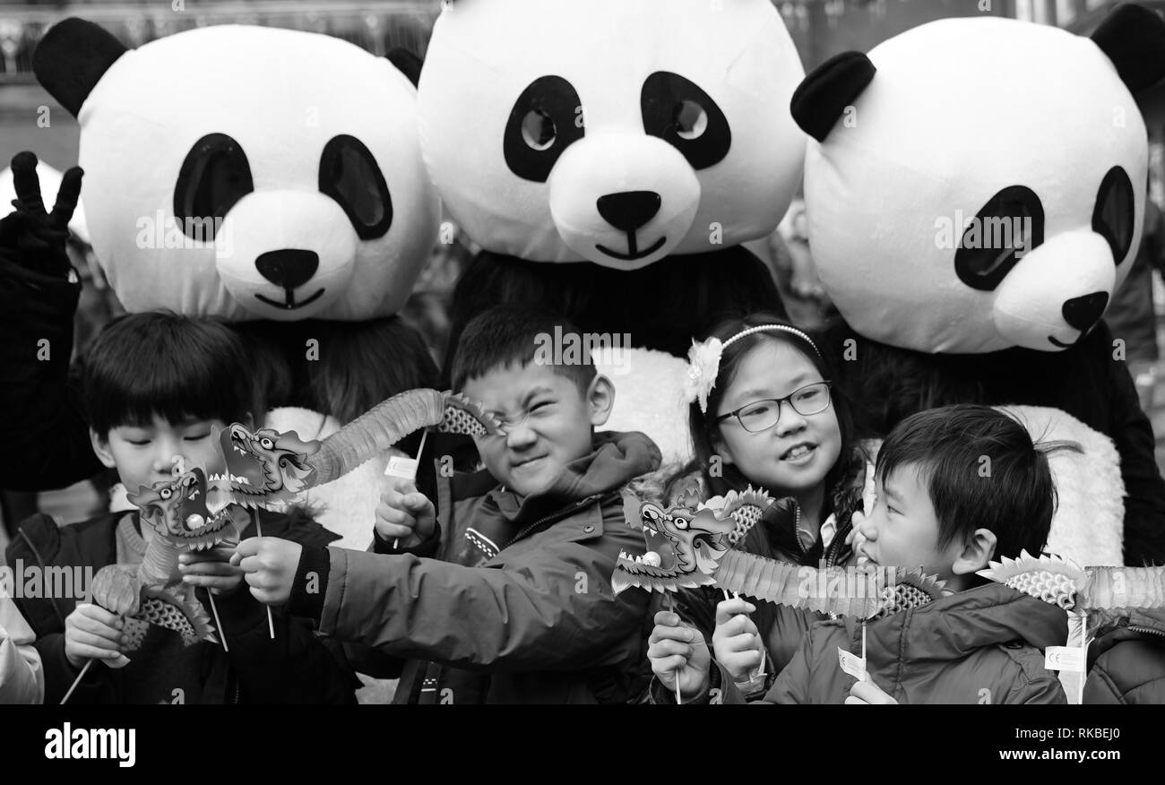 Chinese new year in Chinatown London with pandas in black and white and Chinese kids photographed in the forefront. Stock Photo