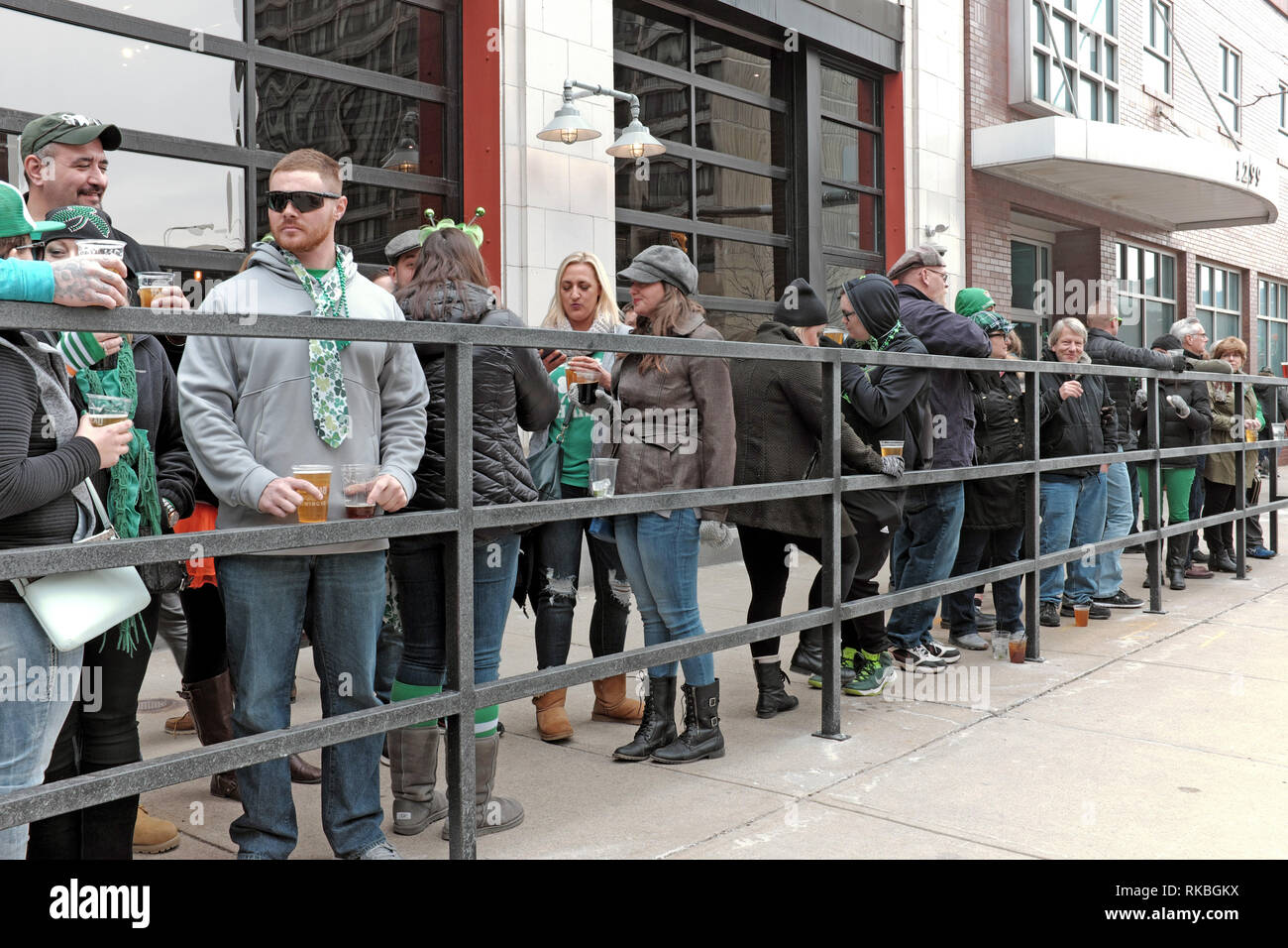 Fenced in beer-drinking St. Patrick's Day celebrants outside Masthead Brewing on Superior Avenue in Cleveland, Ohio on March 17, 2017. Stock Photo