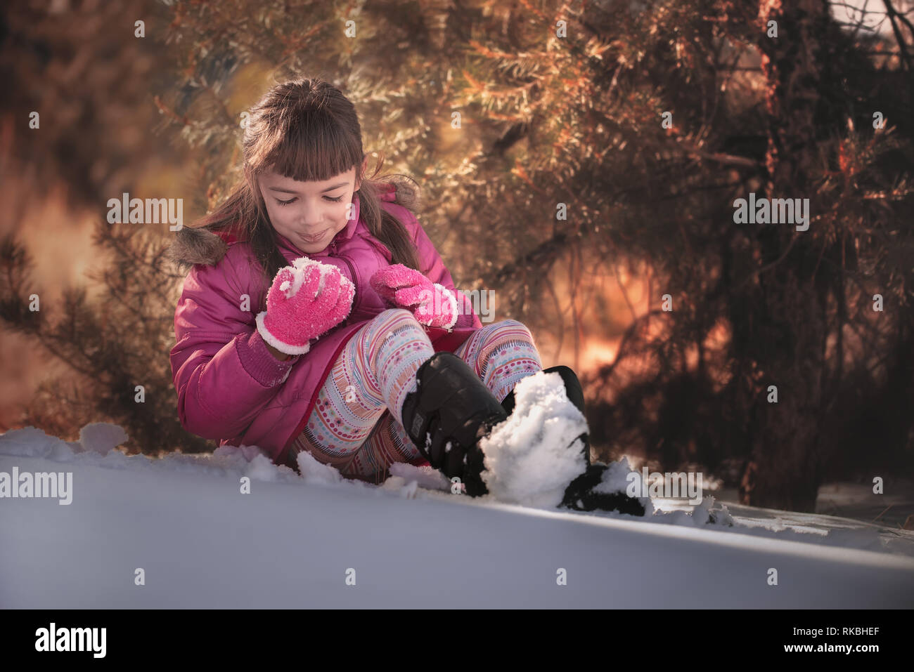 8 years old girl playing in the snow Stock Photo