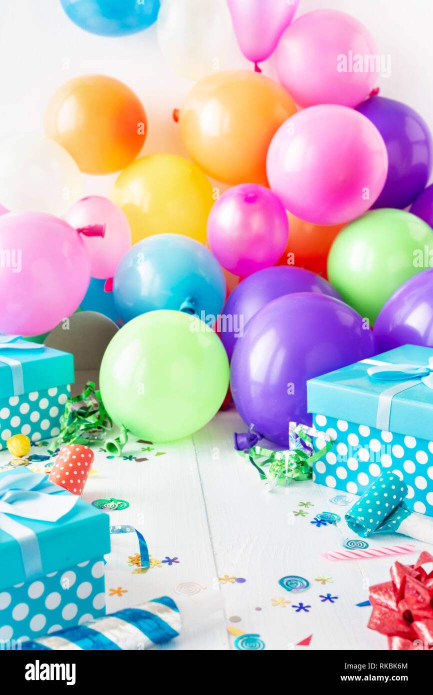 Birthday party background with decoration, balloon, confetti, serpentine,  birthday hat and gift boxes on white wooden teble with place for your  object Stock Photo - Alamy