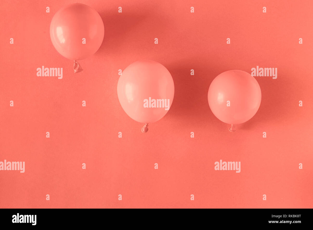 Coral balloons in coral pastel background Stock Photo - Alamy