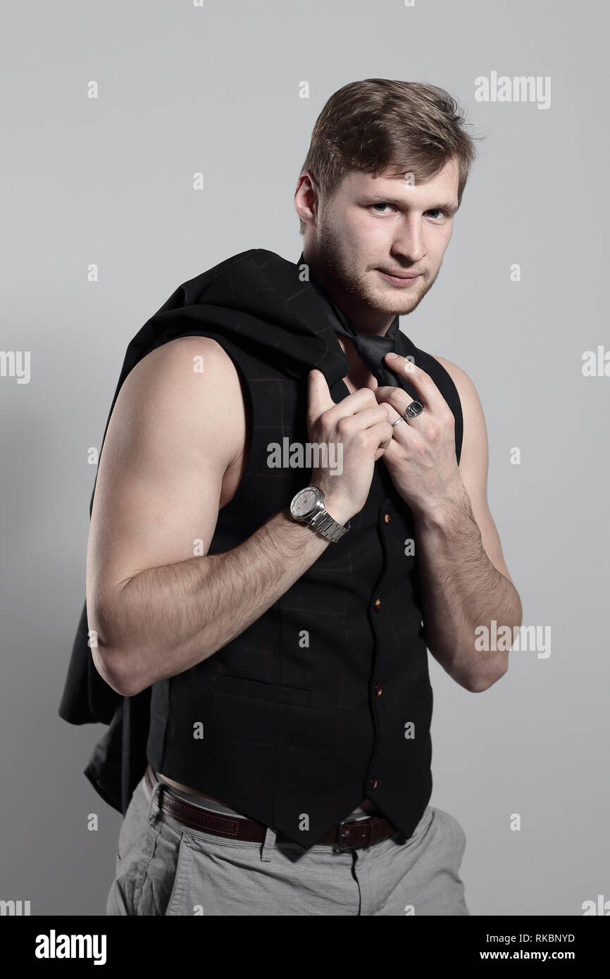 young businessman in a business suit without a shirt takes off his tie