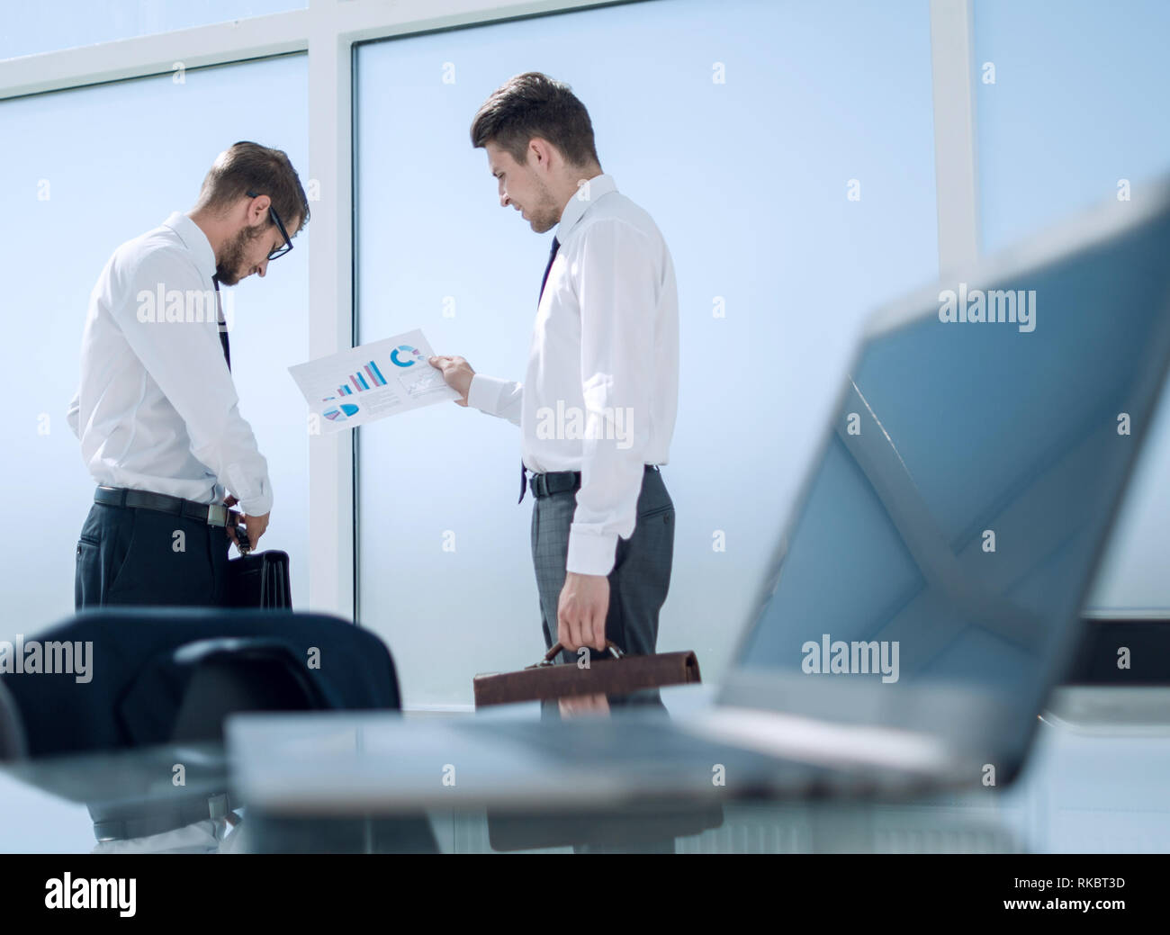 side view of businessmen shaking hands in office building Stock Photo ...